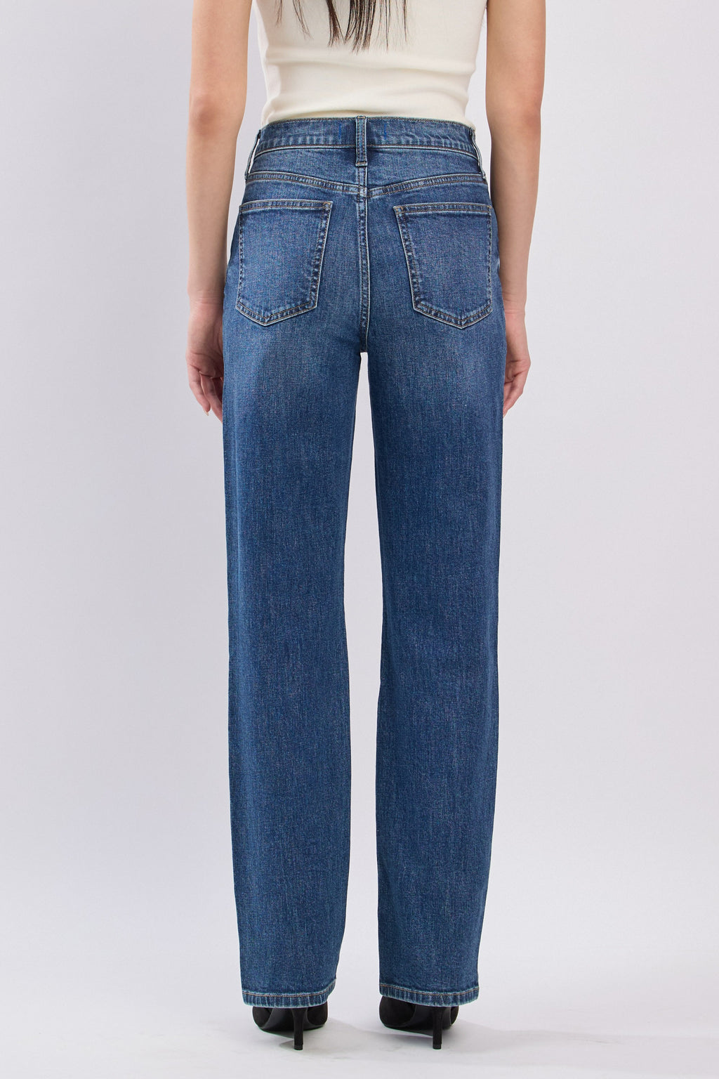 Person wearing blue jeans on a white background