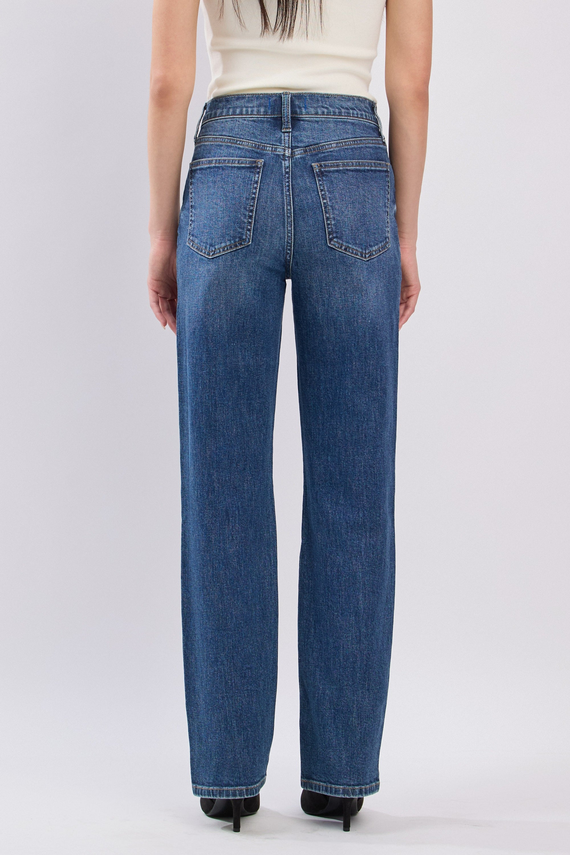 Person wearing blue jeans on a white background