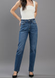 Woman wearing blue jeans and a white top on a plain background