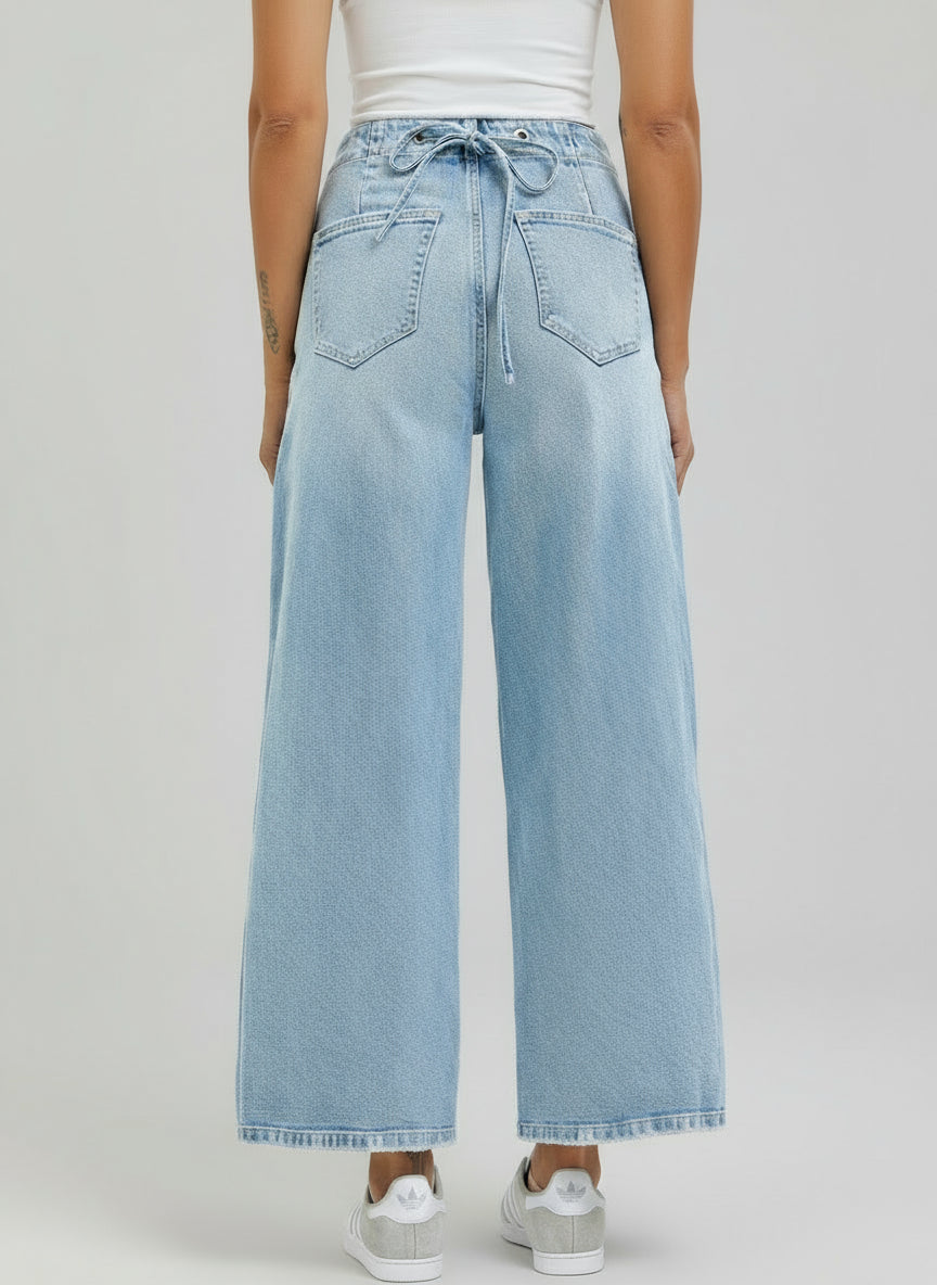 Light blue wide-leg jeans worn by a person on a white background