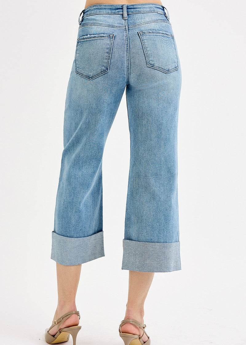 Light blue jeans with rolled-up cuffs on a white background