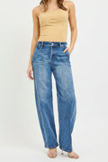 Woman wearing a beige strapless top and blue jeans on a white background